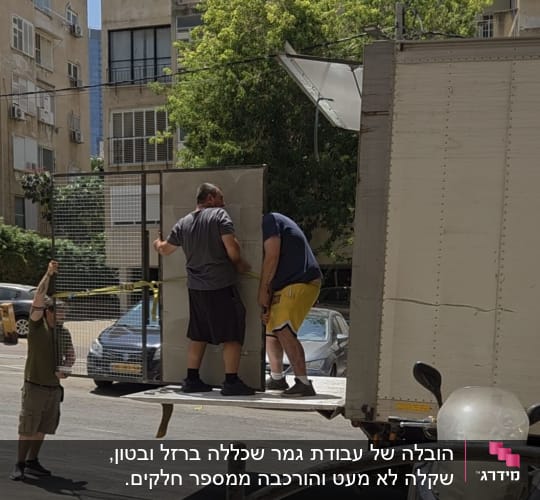אנשים מעמיסים רהיט למשאית ברחוב עירוני